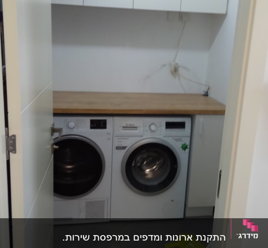 חדר כביסה עם מכונת כביסה ומייבש